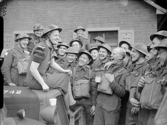 Gracie Fields shares a joke with troops in a village near Valenciennes, France, April 1940